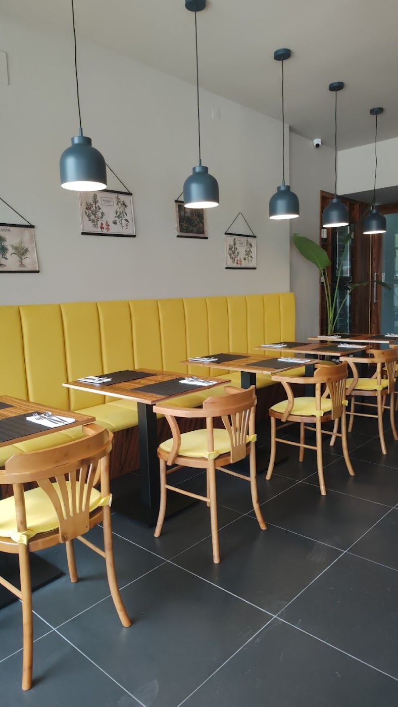 Banco amarelo e estampas botânicas na sala